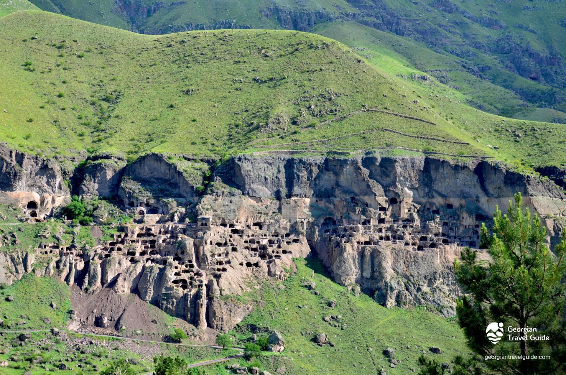 Vardzia cave monastery carved into a green cliff face, with hundreds of rock-cut rooms across multiple tiers, Samtskhe-Javakheti